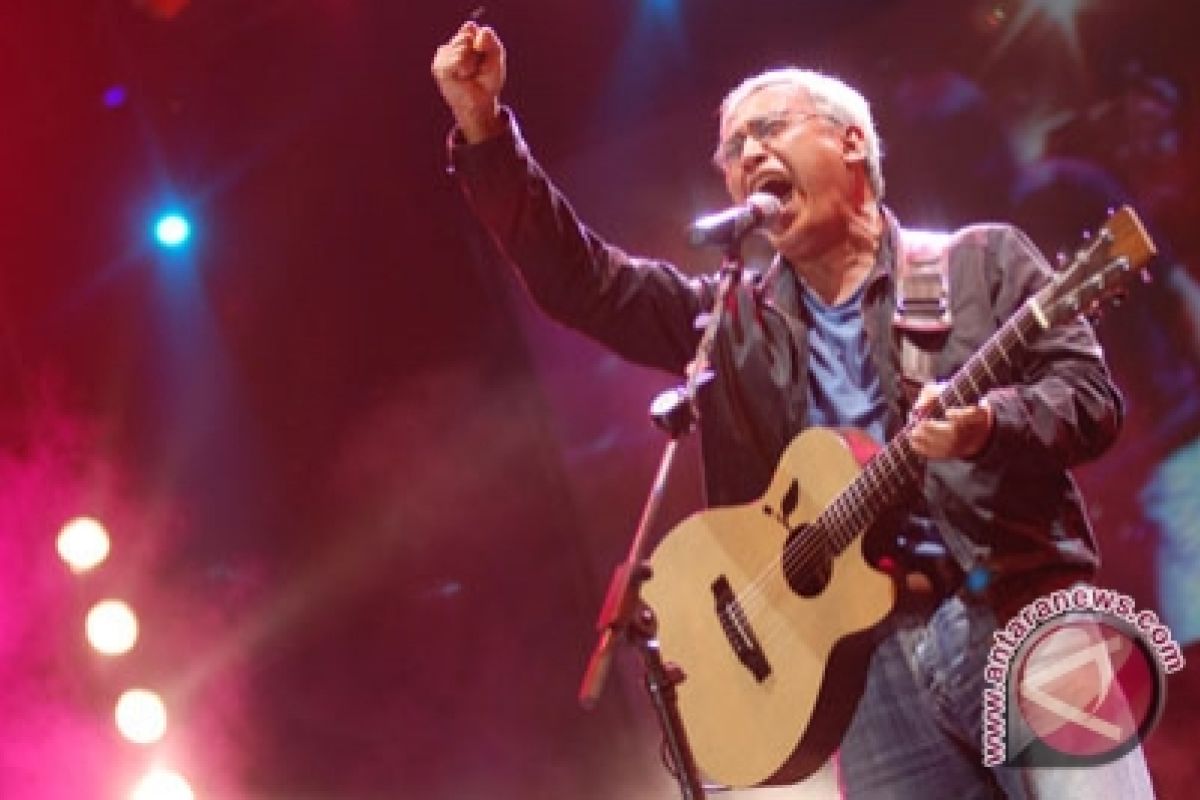 Iwan Fals bernyanyi dengan gitar