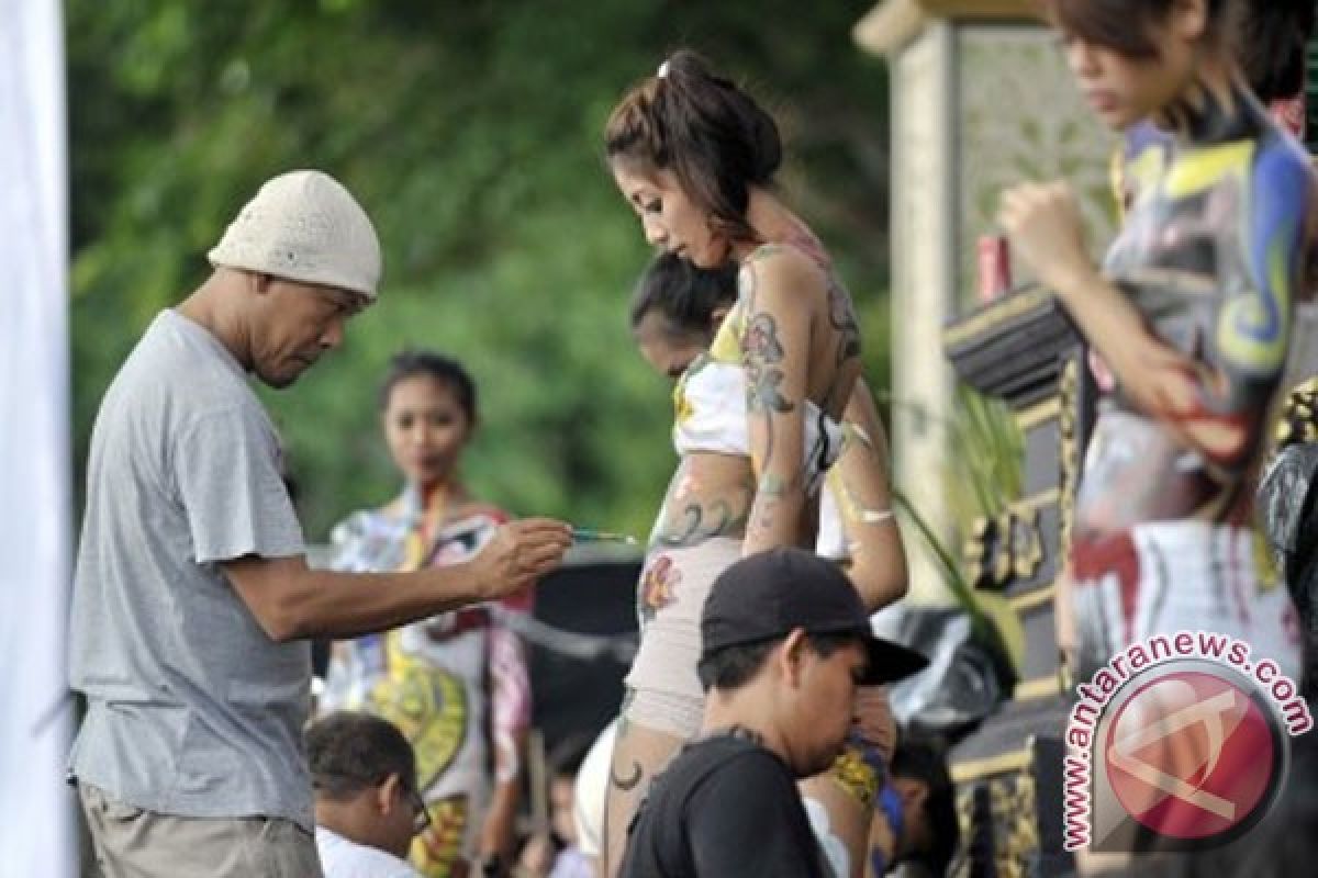 Foreign tourists join body painting attraction in Bali