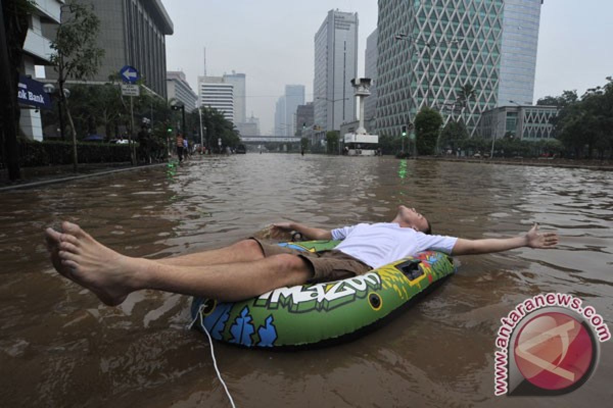 Bule bermain perahu karet di tengah banjir