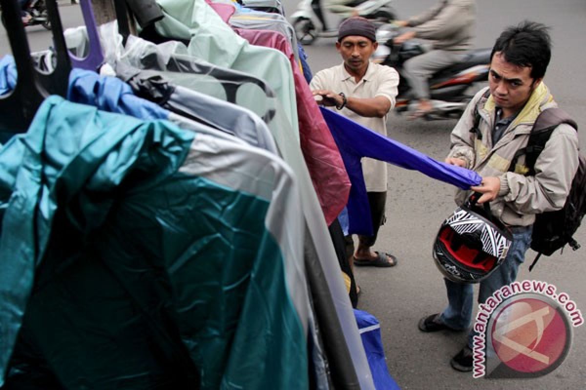 Jas hujan warna cerah jadi pilihan pengendara motor 