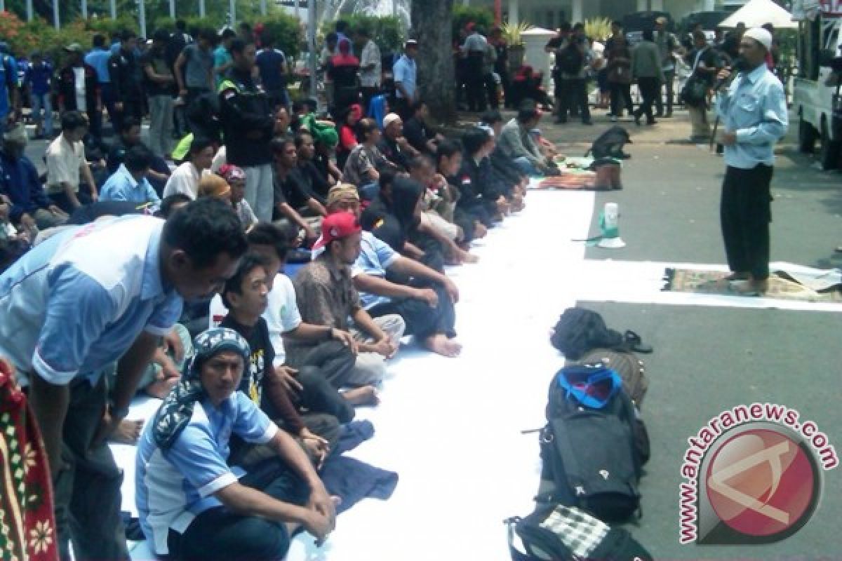 Buruh sholat Jumat di depan Balai Kota