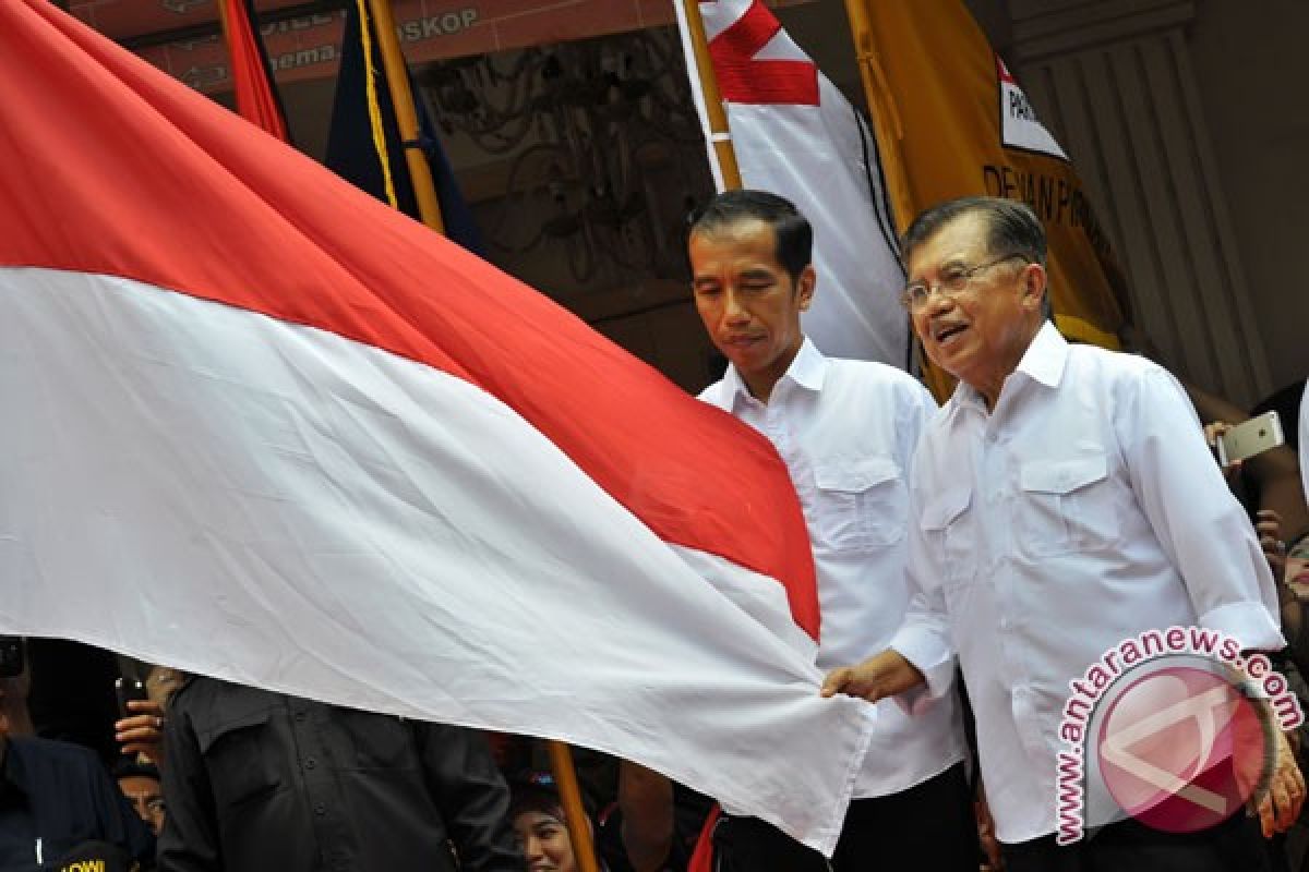 Jokowi-JK cium bendera usai deklarasi