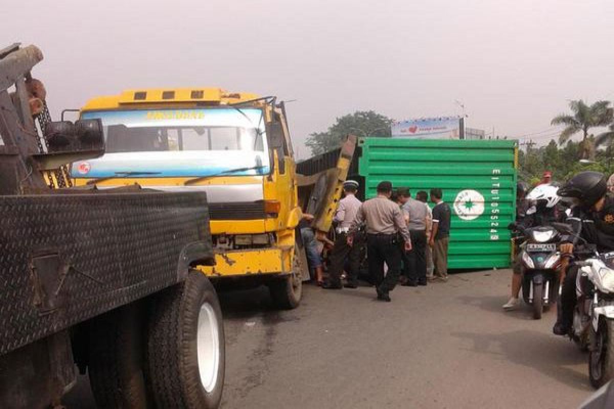 Kontainer ekspedisi bermuatan pipa 30 ton terbalik