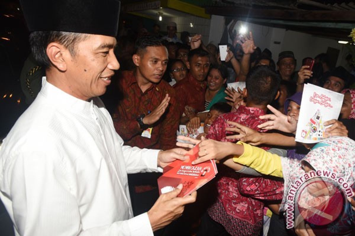 President Jokowi distributes health cards to plantation workers