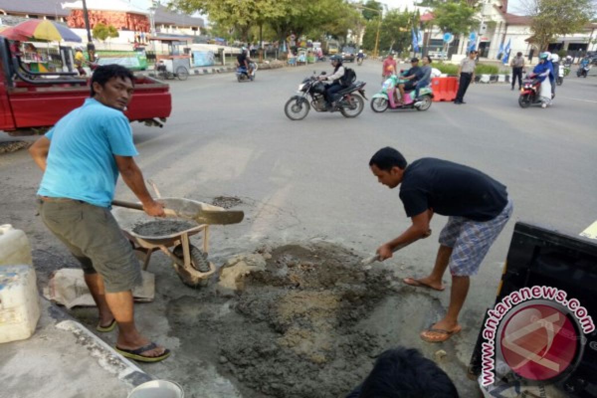 Warga Gotong Royong Menambal Jalan Negara