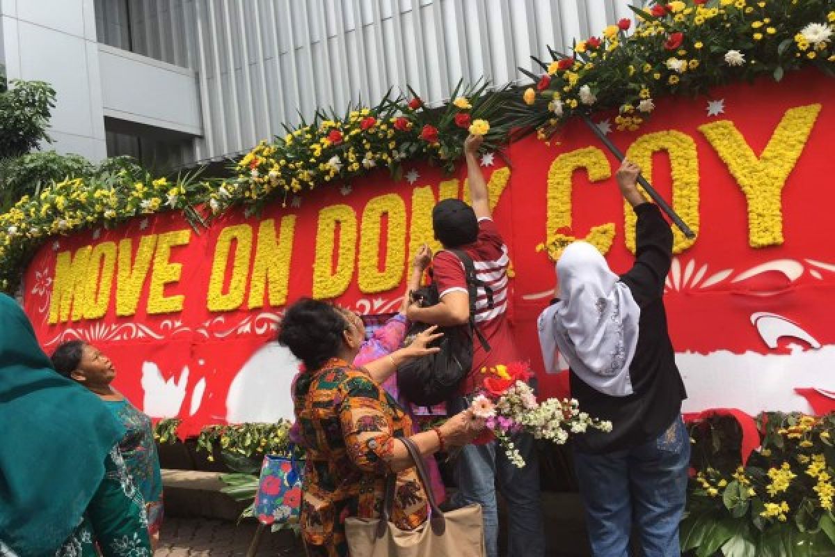 Pengunjung ramai-ramai preteli karangan bunga "Ayo Dukung Oke Oce" di kantor Ahok