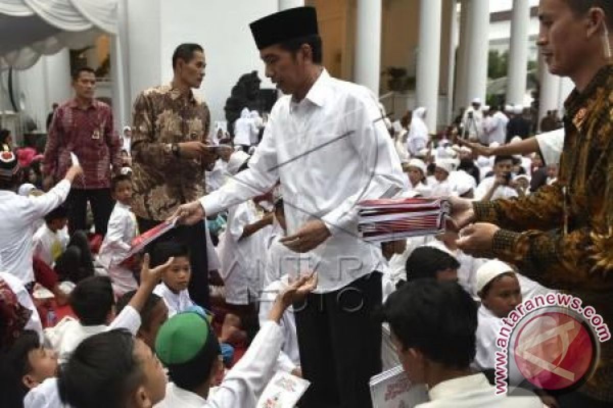 President Jokowi distributes books among children at Cipanas State Palace