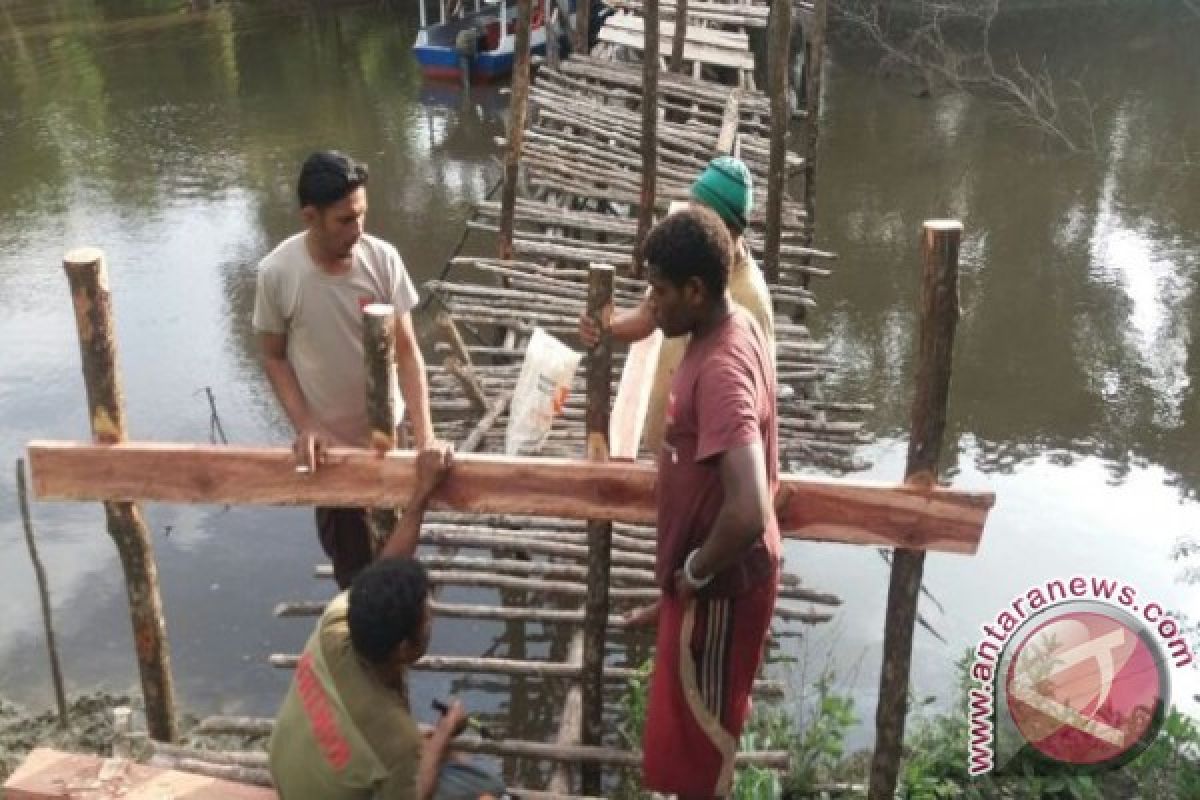 Bhabinkamtibmas bersama warga Kampung Sanggase perbaiki jembatan