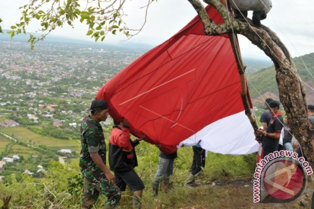 Merah putih raksasa berkibar di puncak bukit 