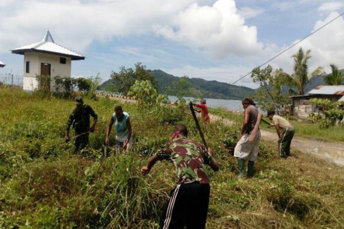 Babinsa Koramil Yaptim bersama warga bersihkan lingkungan Kampung Mereruni