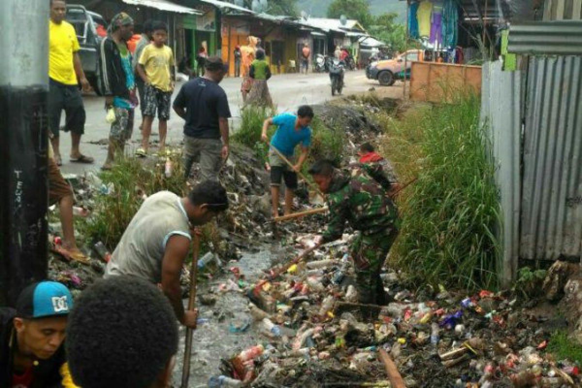 Babinsa Koramil Moanemani bersihkan parit tersumbat 