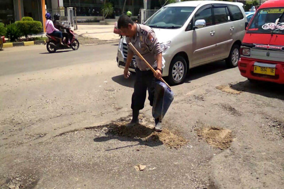 Anggota Satlantas Polres Cilegon Uruk Jalan Berlubang