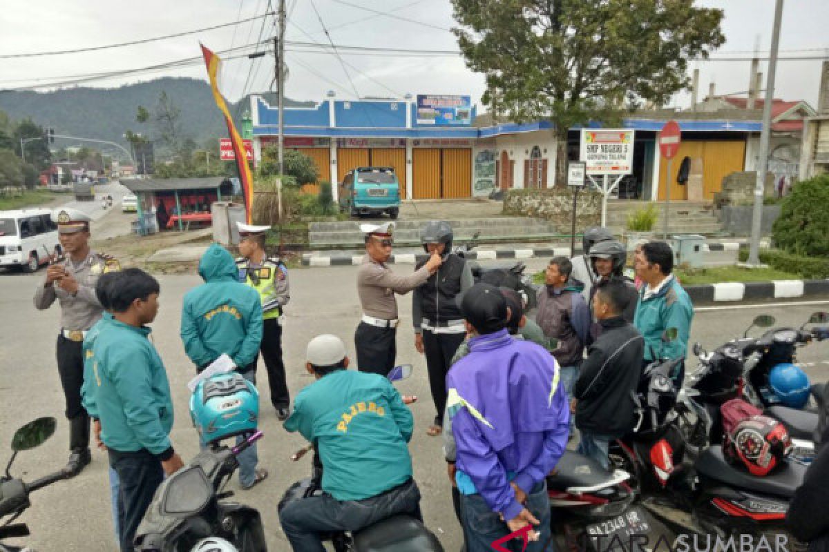 Tingkatkan kesadaran tertib berlalu lintas, polisi berikan helm dan bunga kepada pengendara