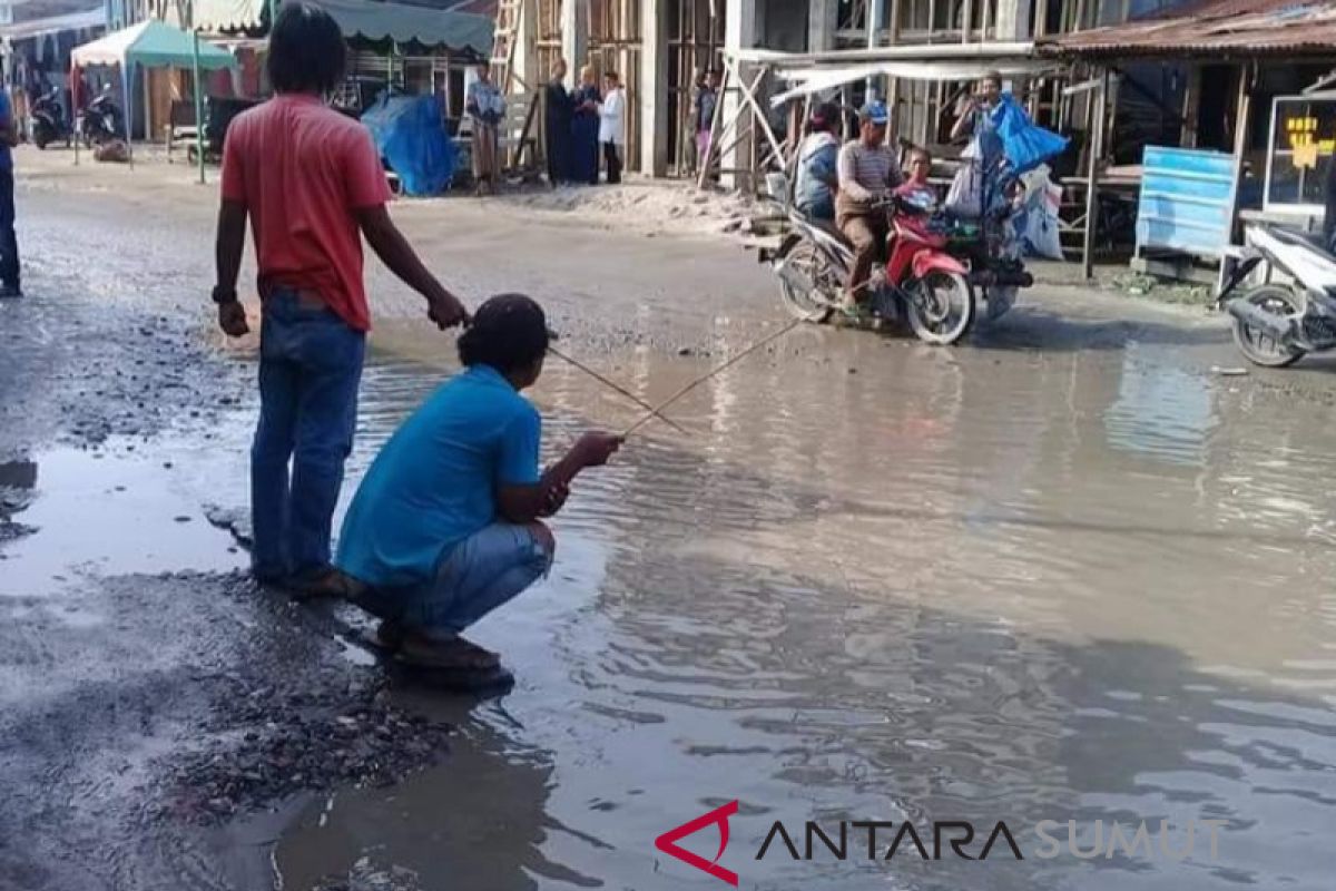 Warga mancing di jalan mirip kolam