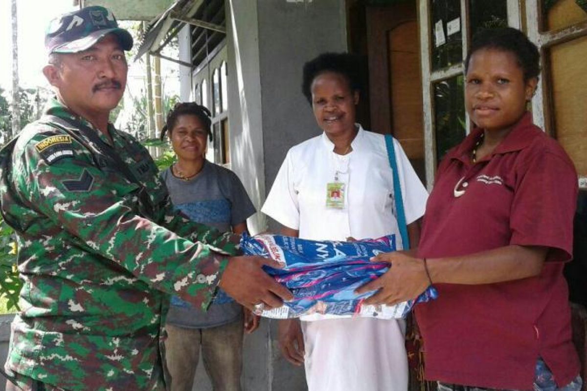 Babinsa Koramil Timika bantu petugas puskesmas bagikan kelambu berinsektisida