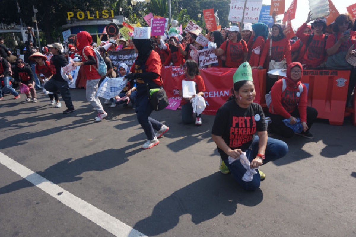 Beberapa pekerja inisiatif punguti sampah di sela aksi Hari Buruh