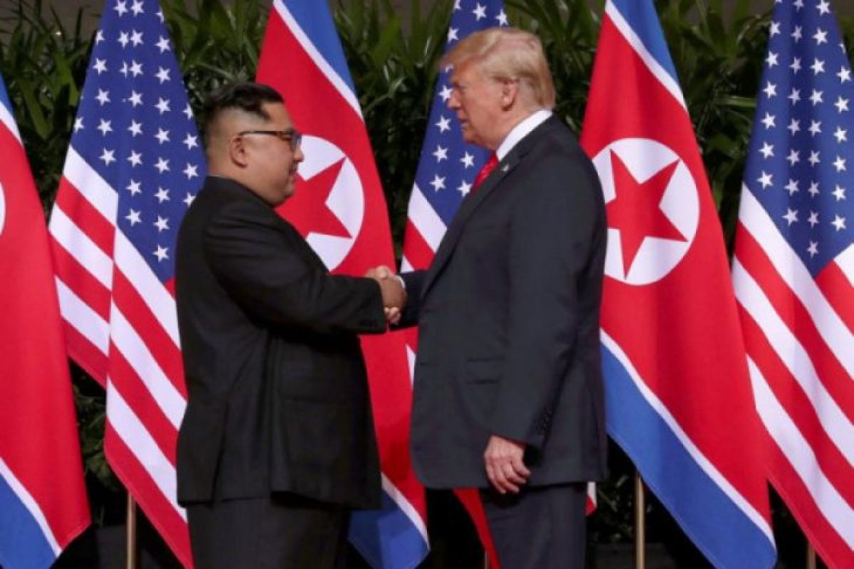 Donald Trump dan Kim Jong Un akhirnya berjabat tangan