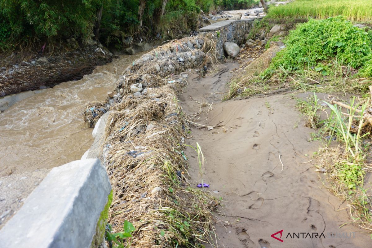 Tanggul penahan banjir jebol  akibat luapan air Sungai Batang Ayumi