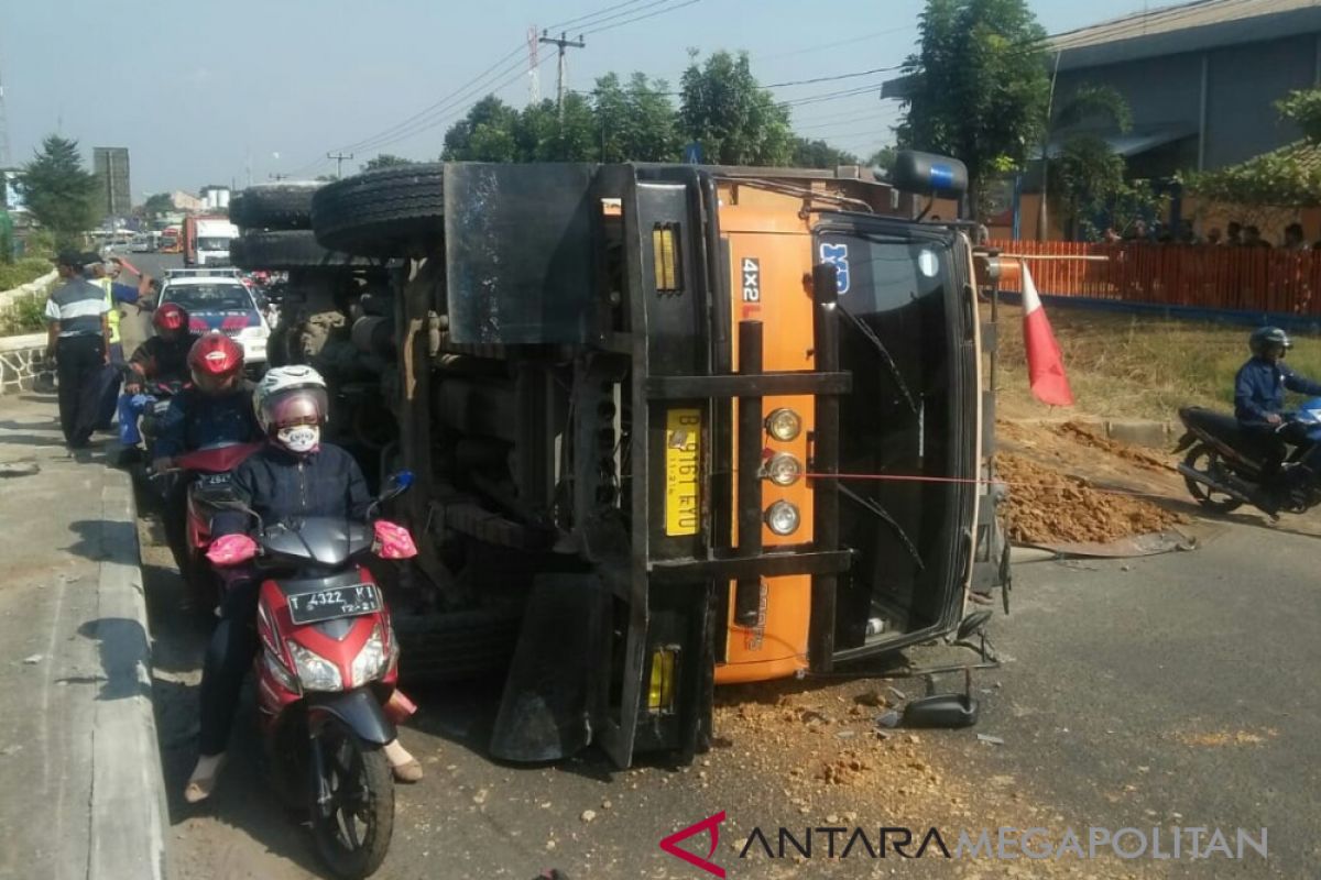 Truk muatan tanah merah terbalik di Karawang