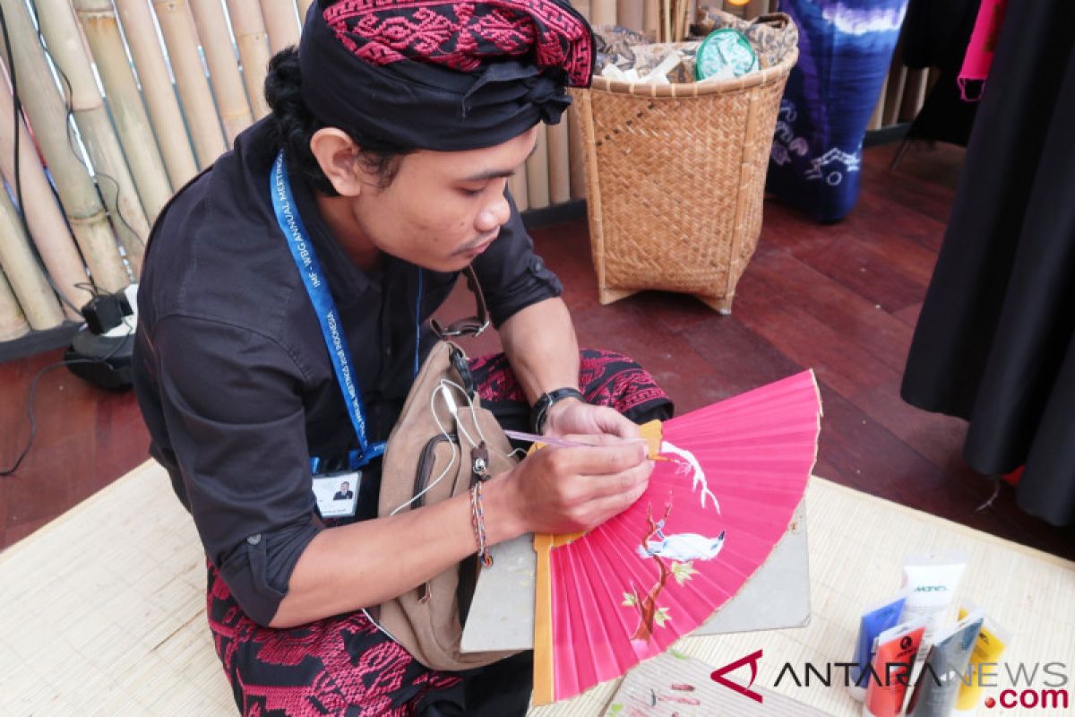 IMF-WB - Balinese craftsman prepares special painted fan for President Jokowi