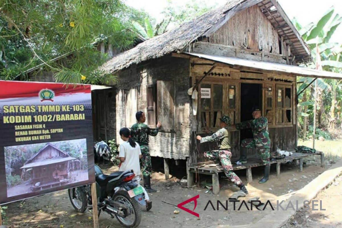 Soldiers dismantle a hollow and leaking house