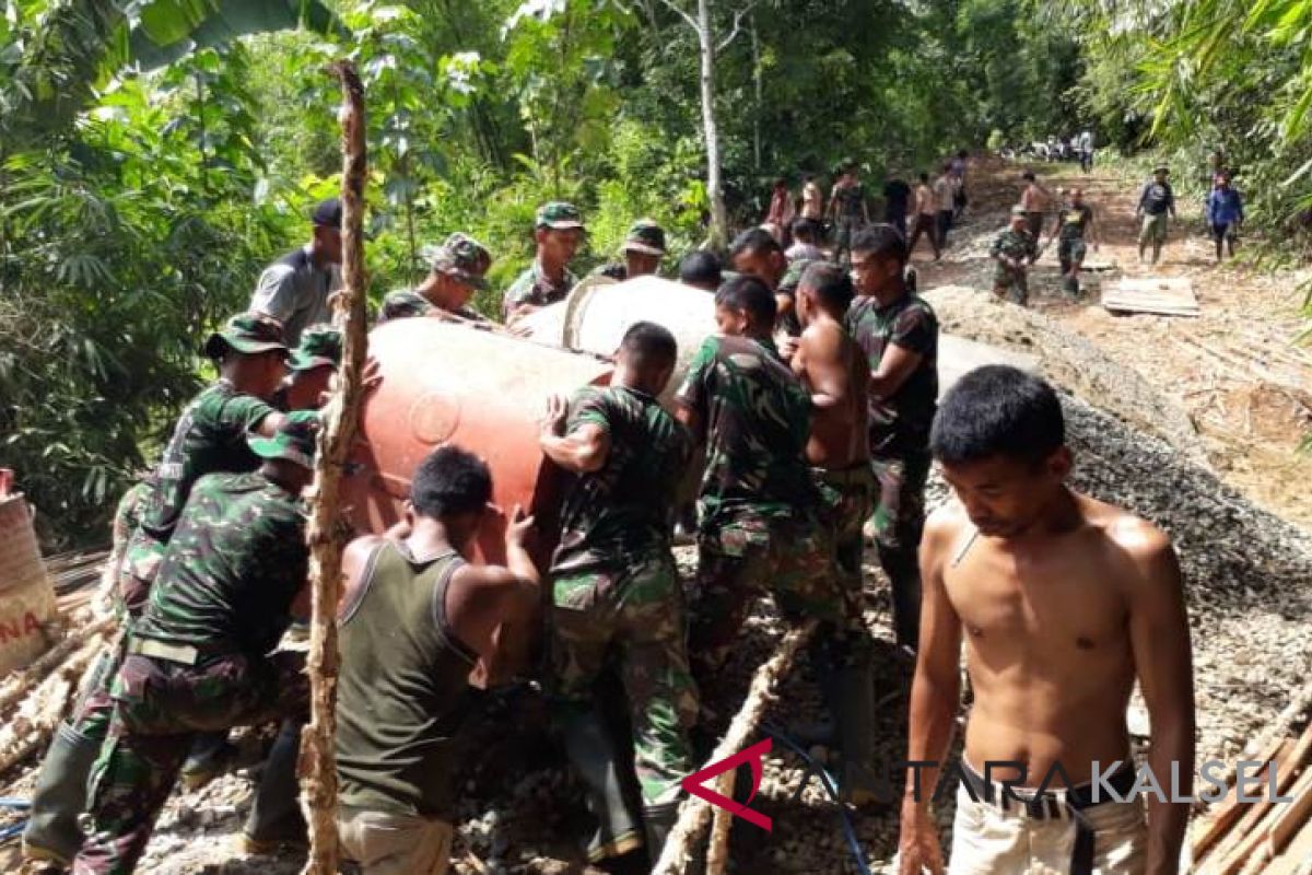 Satgas gotong royong dengan warga angkat mesin molen