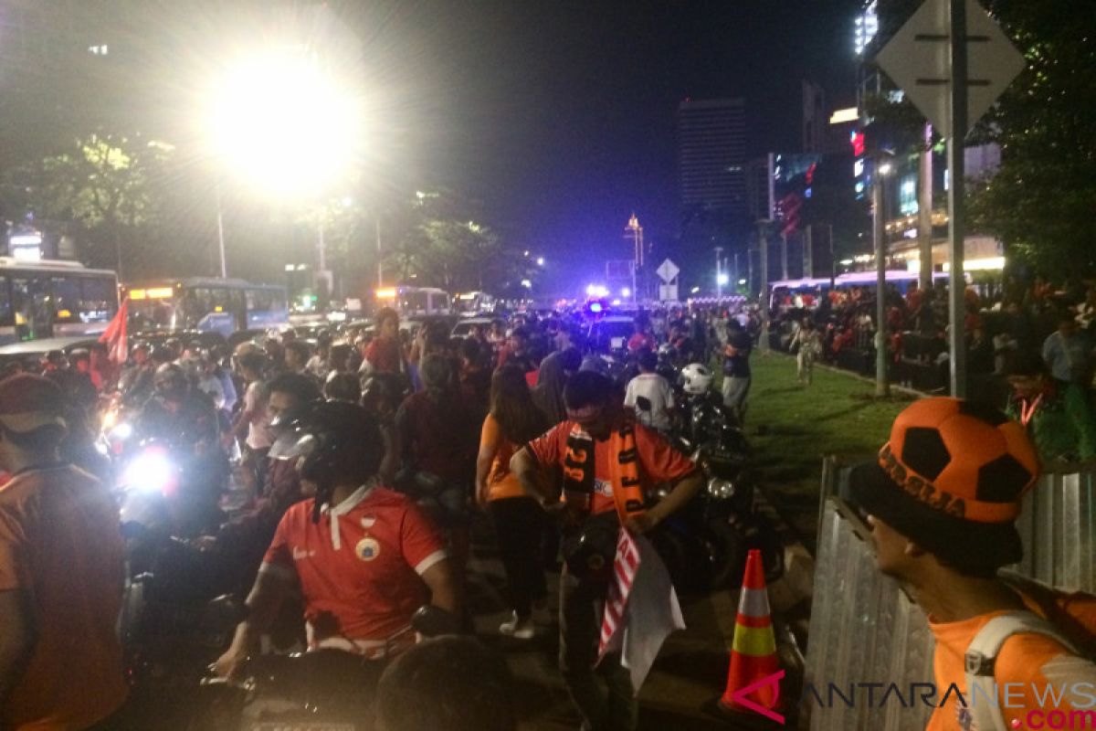 Pendukung tunggu konvoi pemain di luar Stadion Gelora Bung Karno