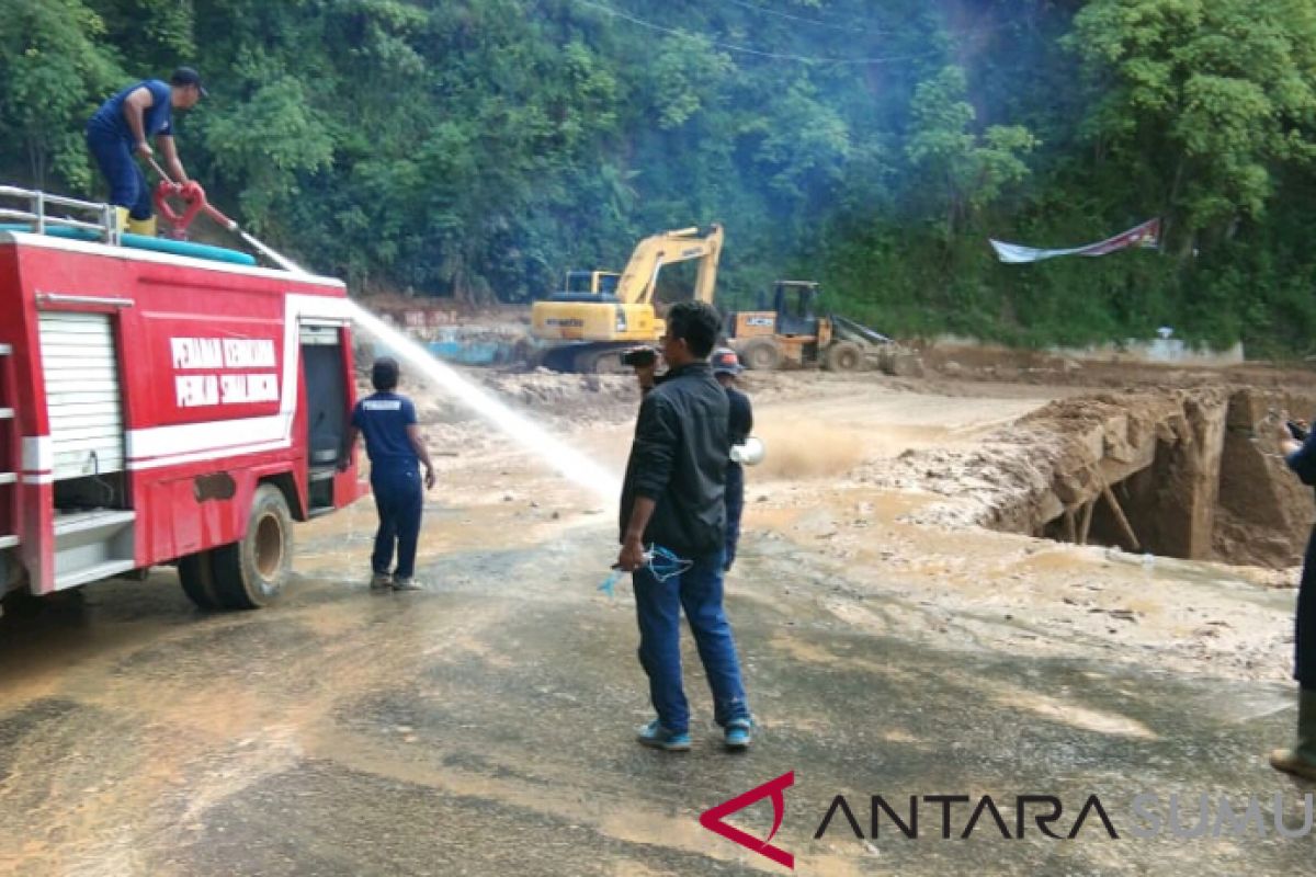 Mobil pemadam kebakaran semprot material longsoran