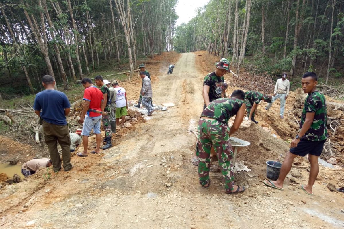 TNI bersama warga  gotong royong membuat drainase