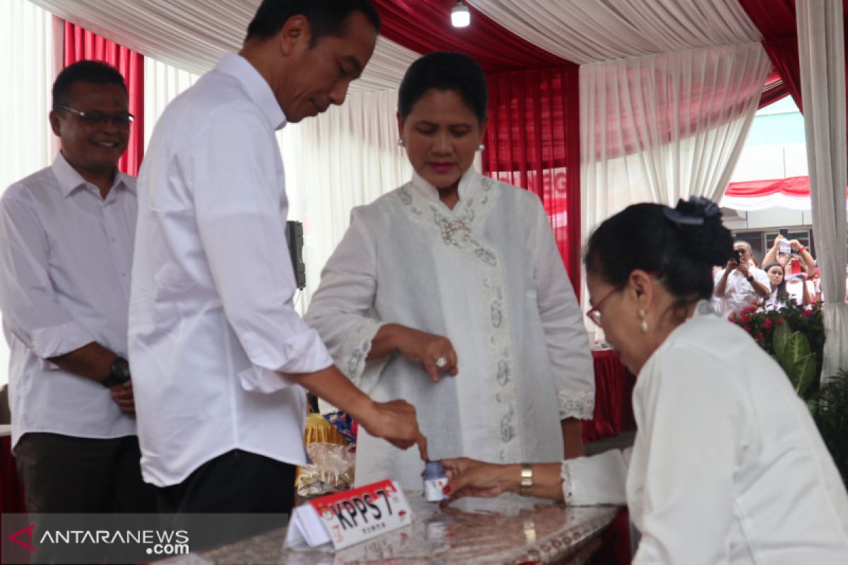 Presiden Jokowi dan ibu Iriana memberikan suara di TPS 008