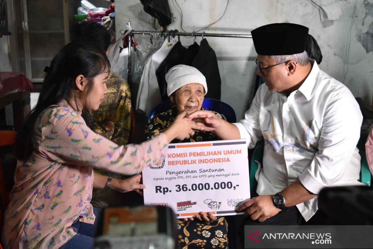 Ketua KPU menyerahkan santunan anggota KPPS yang wafat