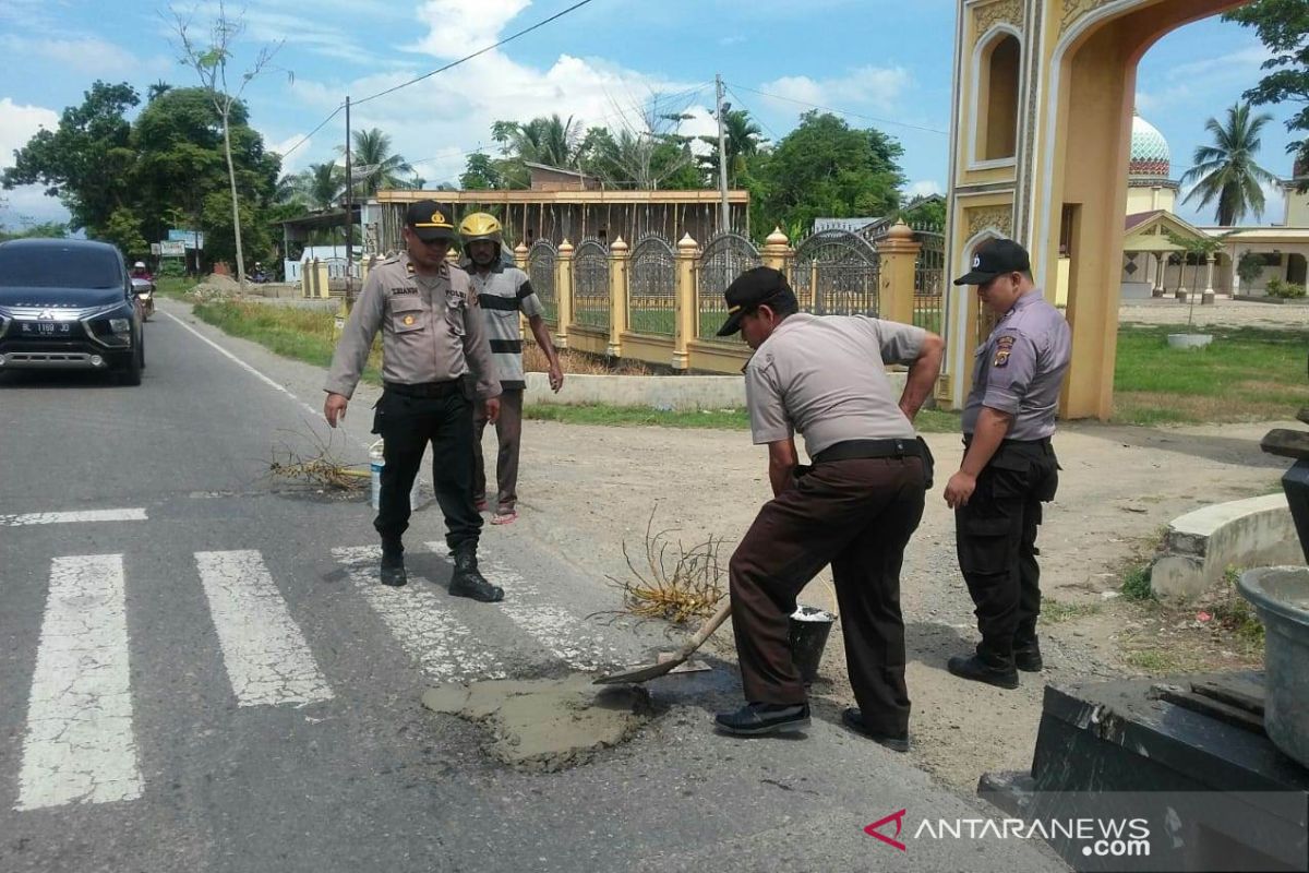 Polisi di Aceh Utara tambal badan jalan raya berlubang