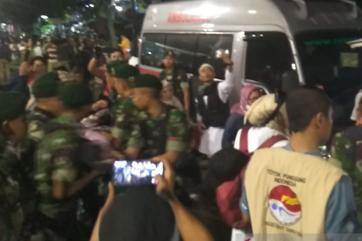 Sejumlah anggota TNI evakuasi peserta aksi yang kelelahan