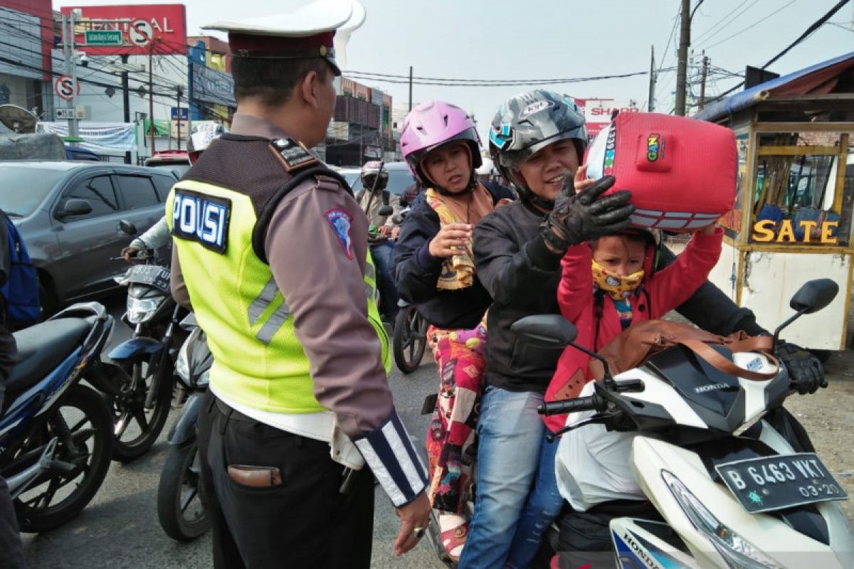 Pemudik motor membawa barang berlebihan melintas Tangerang siang hari