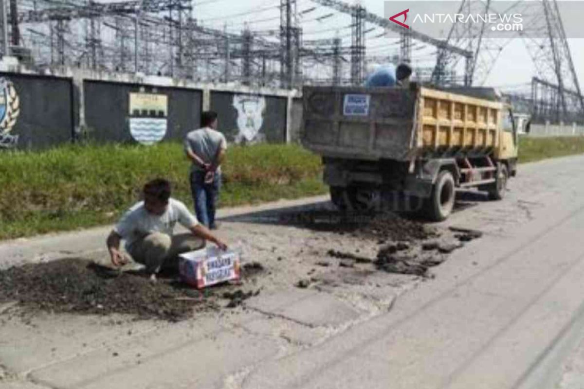 Warga Bekasi memerbaiki kerusakan jalan secara swadaya