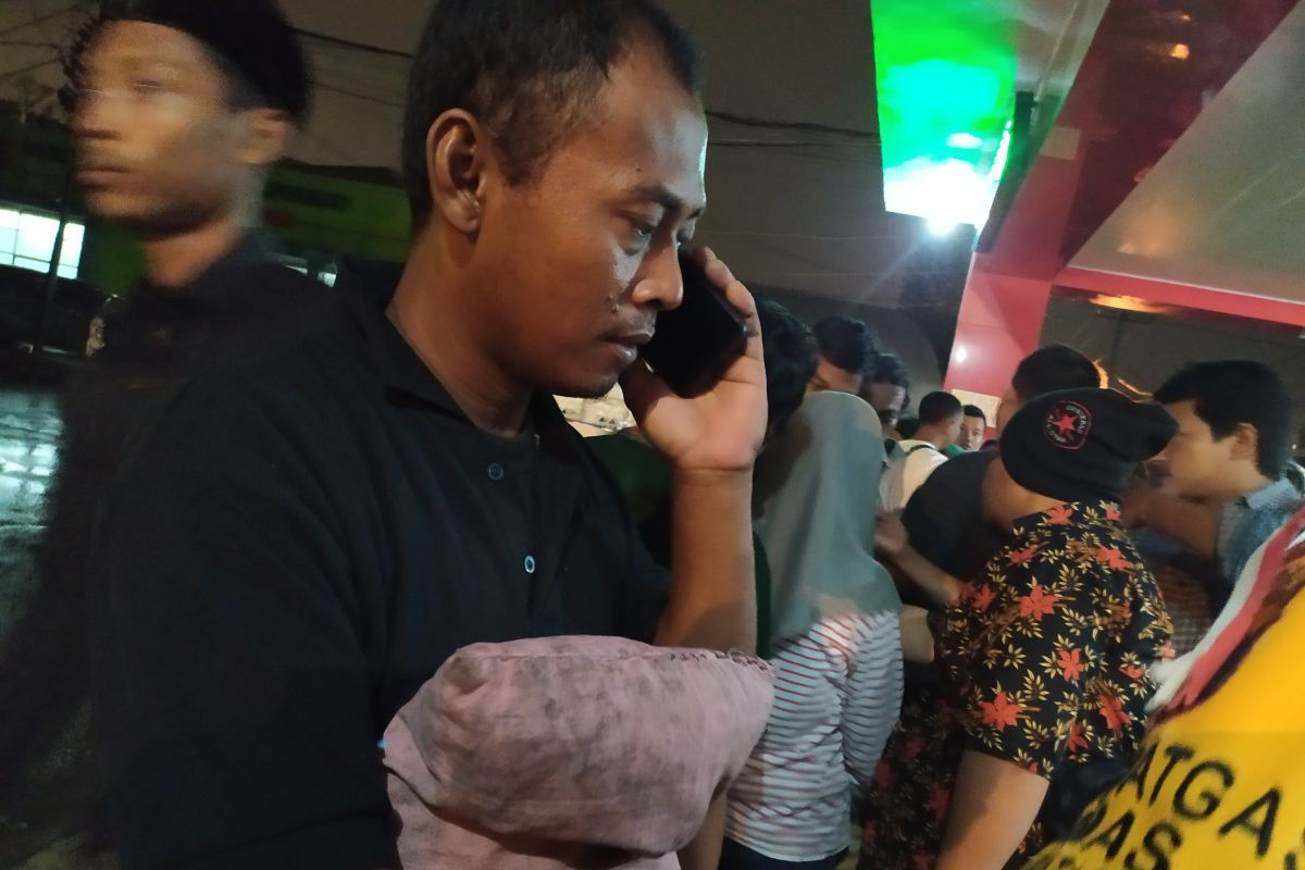 Rusmanto membawa bantal kesayangan anaknya korban kebakaran