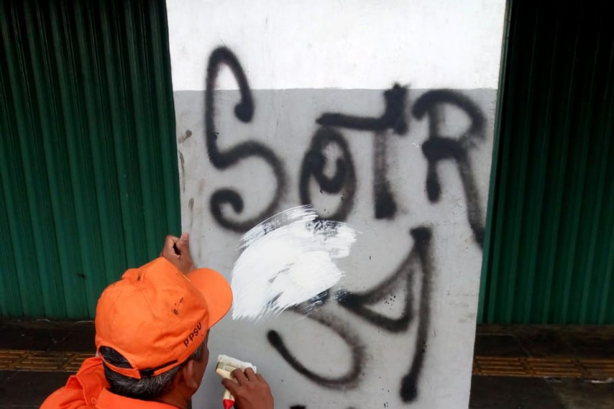 Karena coretan vandalisme, dinding pertokoan Olimo dicat ulang