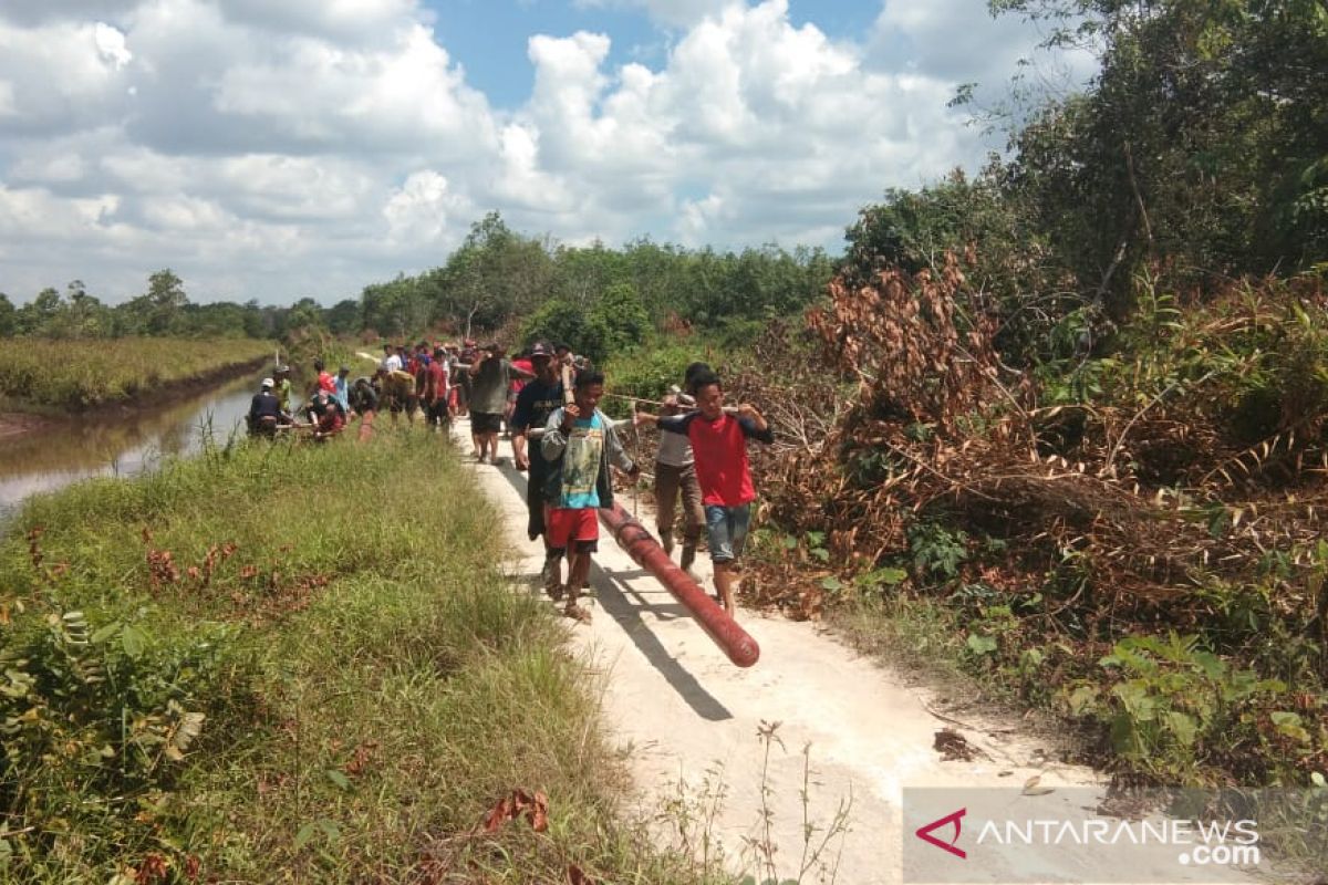 Warga Selakau gotong-royong angkut tiang listrik