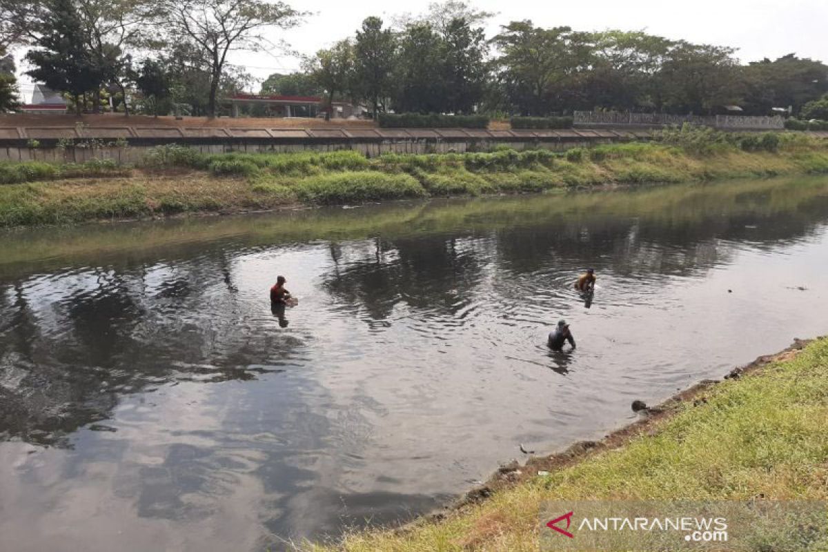 Berburu "harta" di dalam lumpur Kanal Banjir Timur