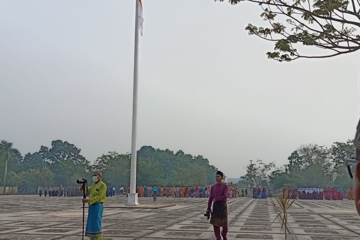 Peringatan HUT Riau diselimuti kabut asap di Siak, peserta upacara pakai masker