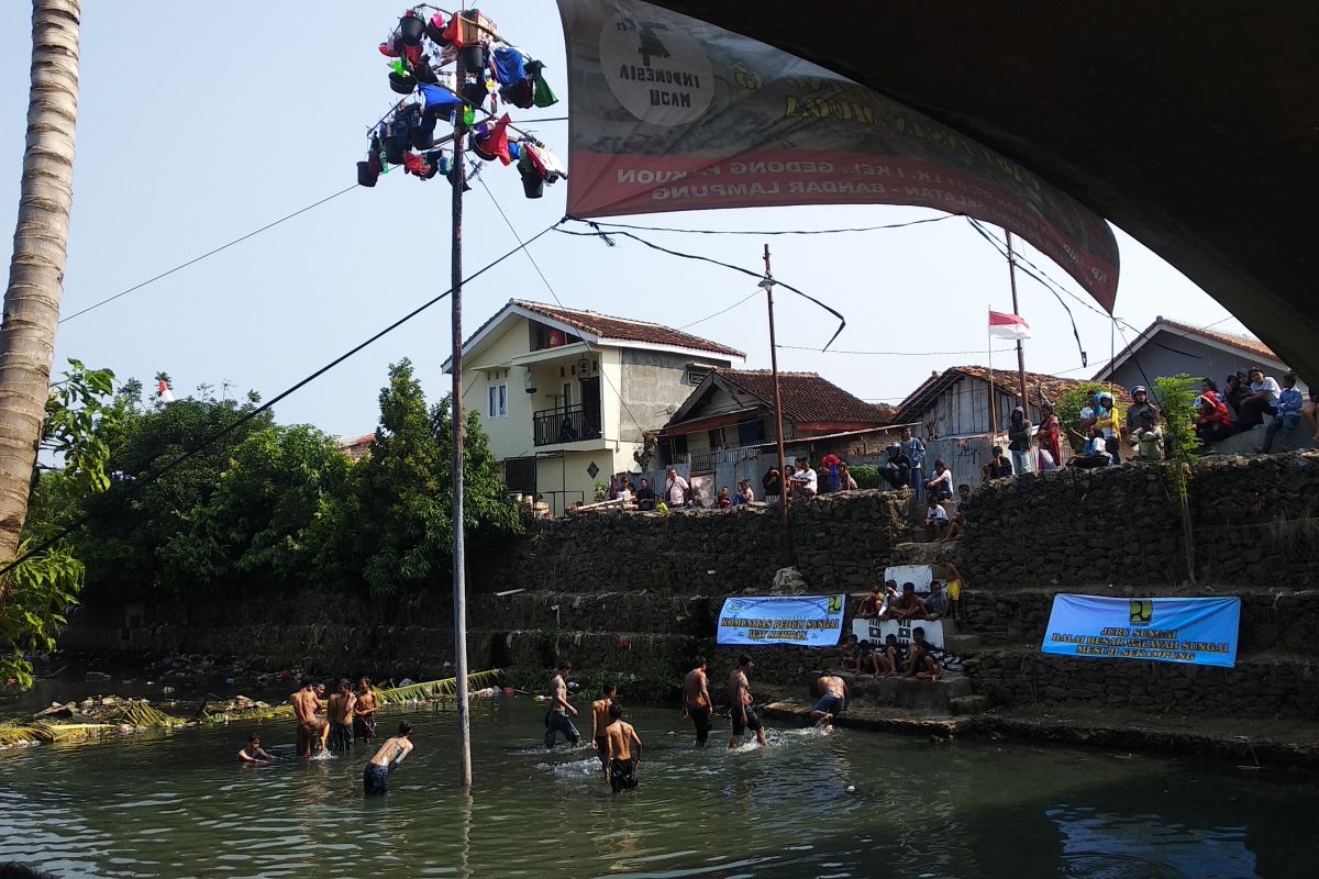 Warga Bandarlampumg gelar lomba panjat pinang di kali kotor