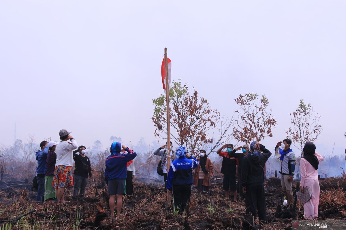 Sekelompok pemuda upacara HUT RI di areal di lahan terbakar