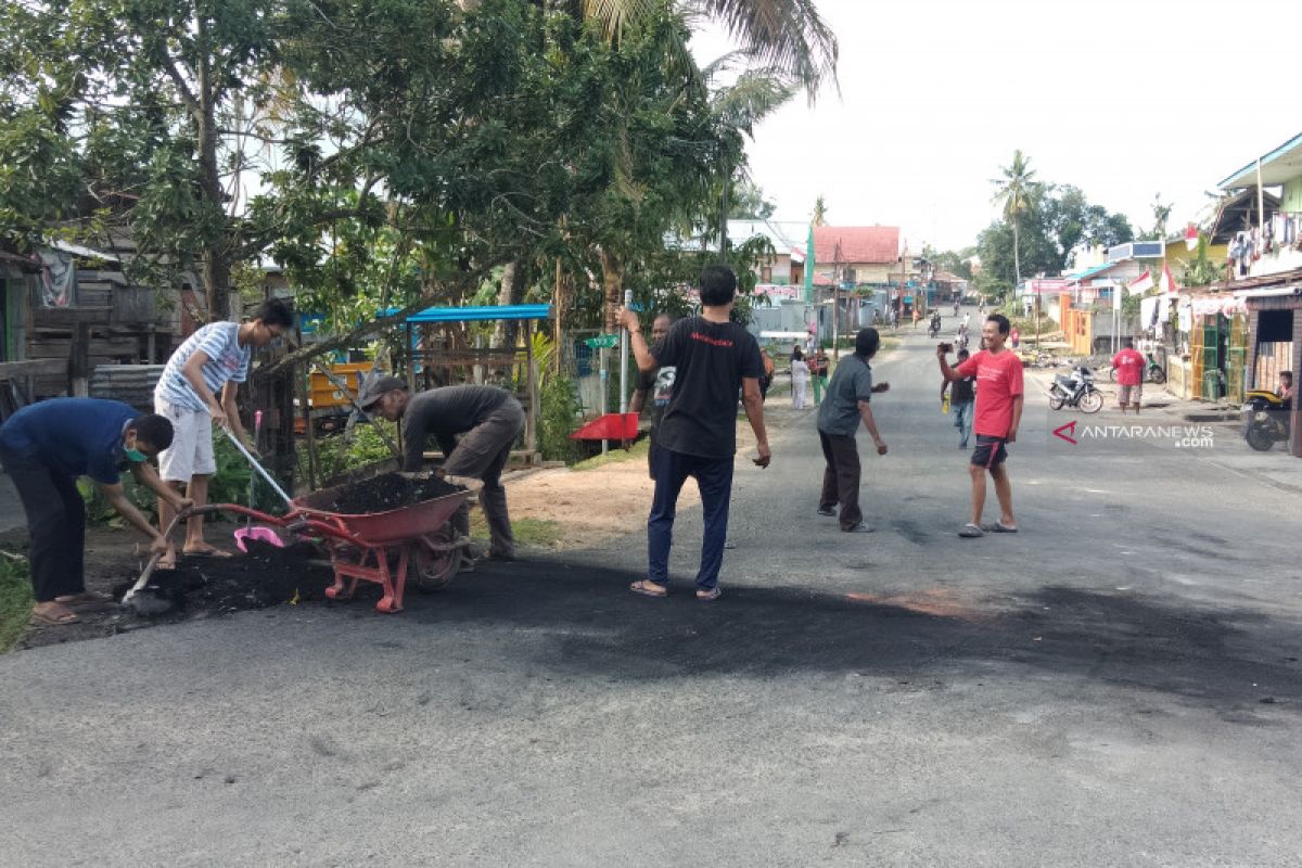 Warga Malanu Papua Barat membersihkan puing-puing pemalangan jalan