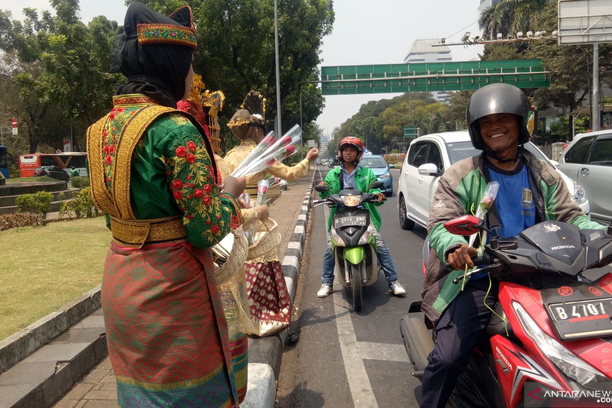 Puluhan wanita berbaju adat bagikan bunga di sekitar Patung Kuda