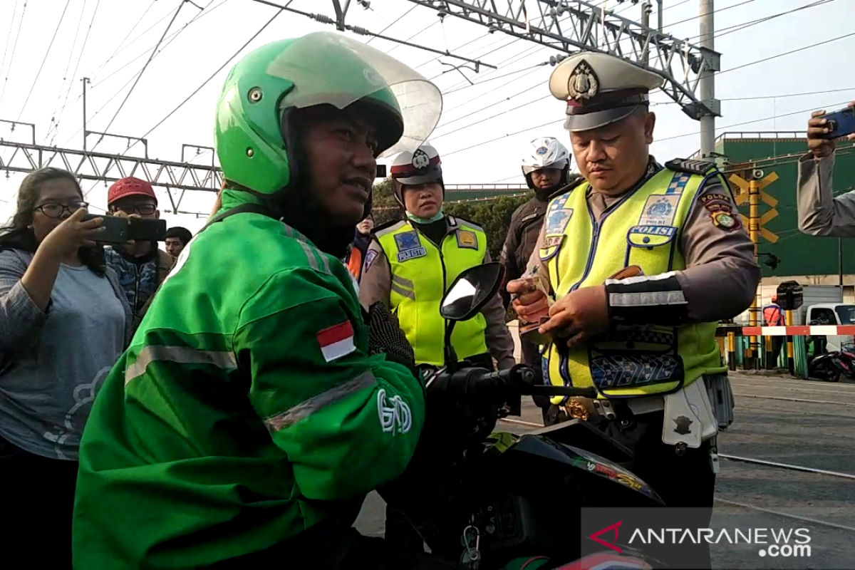 Terobos palang pintu kereta, pengemudi  ojek daring ditilang