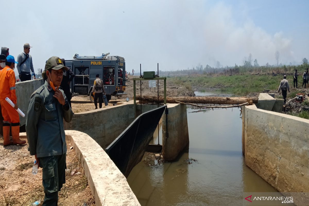 Water flows from Riam Kanan dam to wet burning land around Syamsudin Noor Airport