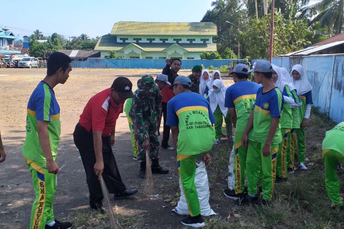 Anggota TNI bersama warga  bersihkan Pasar Muara Uya