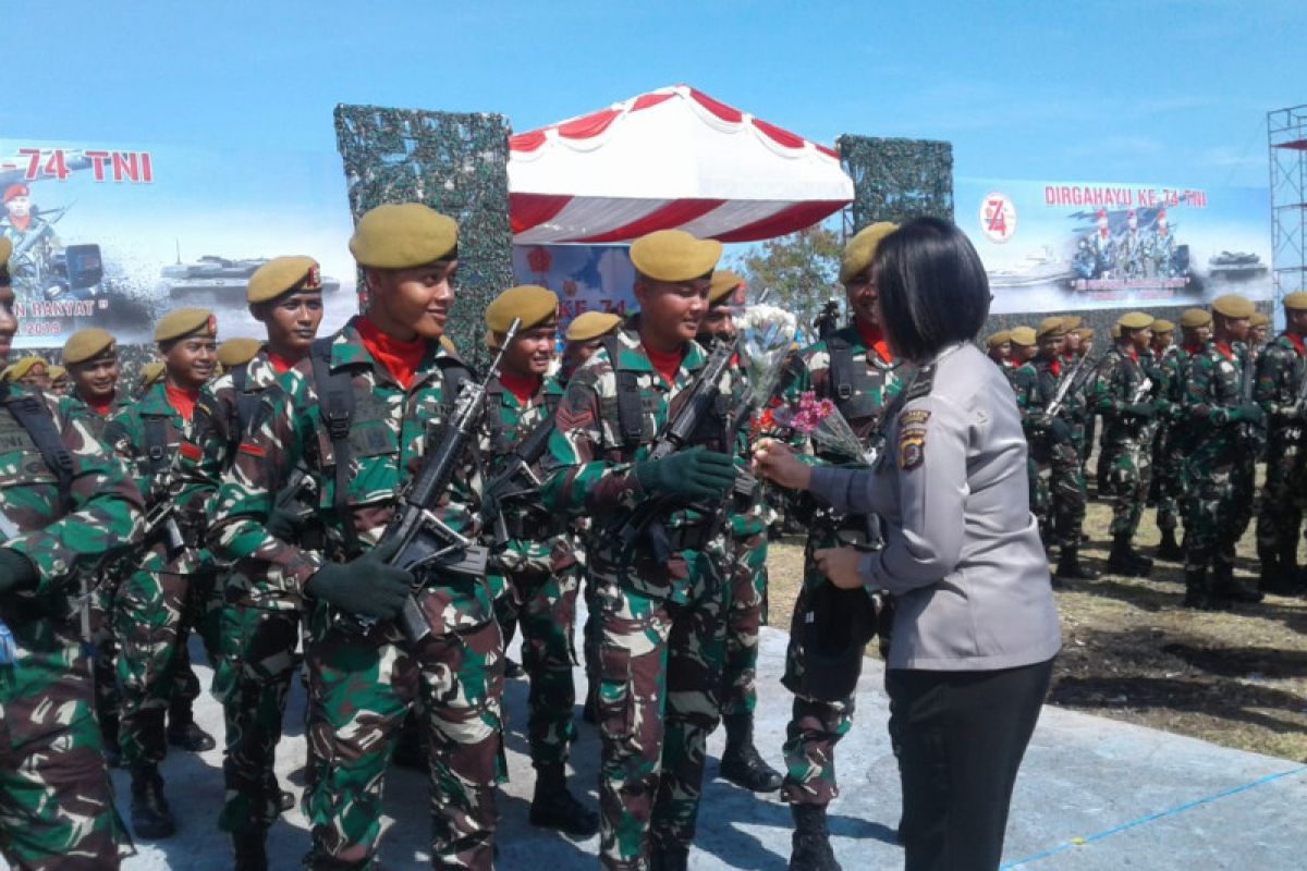 Pemberian bunga dari Polwan kepada prajurit warna HUT TNI