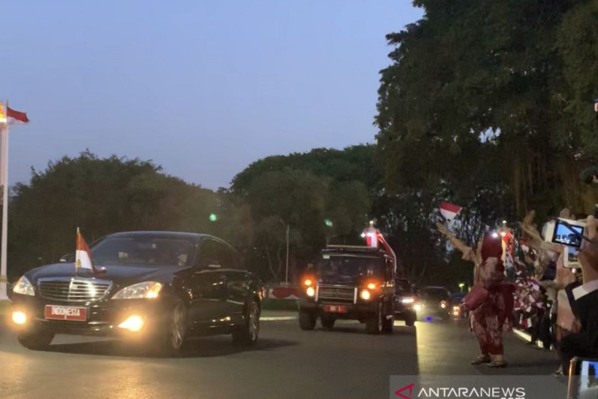 Pegawai Istana lambaikan bendera sambut kembalinya Jokowi ke istana