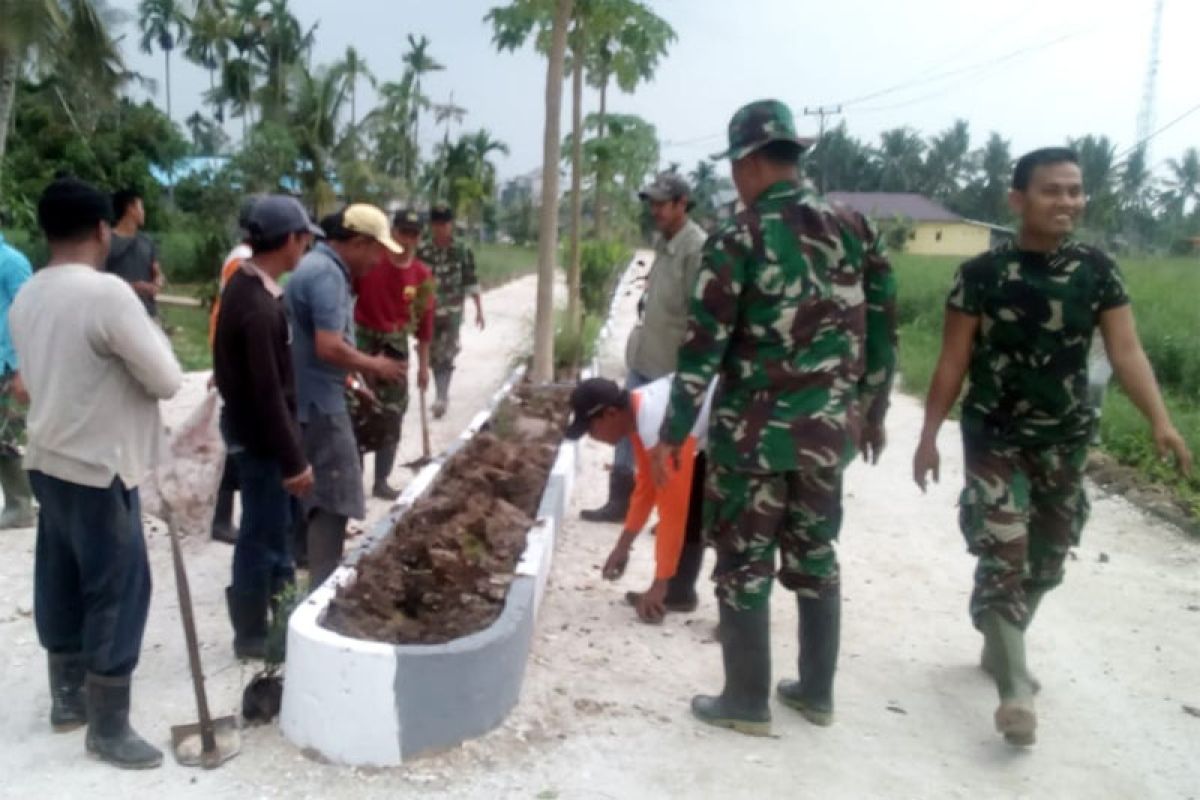 Satgas TMMD Kodim Inhil Menanam Bunga Asoka Di Poros Jalan Tengah